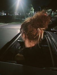 a woman sitting in a car at night