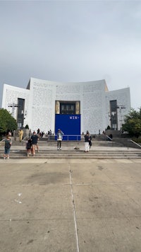 a large building with people walking around it