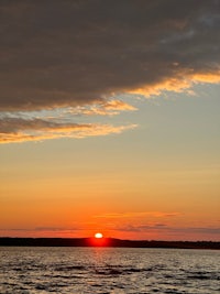 the sun is setting over a body of water