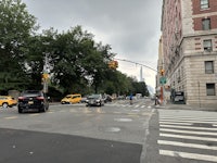 a city street with cars and pedestrians crossing the street