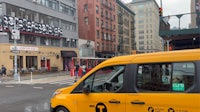a yellow van driving down a city street